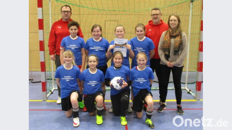 Futsal-Bezirksmeister der D-Juniorinnen wurde der TSV Theuern mit Betreuer Christian Schrott (links), Trainer Klaus Heide. Spielleiterin Janina Zilk (rechts) überreichte bei der Siegerehrung einen Futsal-Ball und die Sieger-Shirts. Bild: Georg Müllner