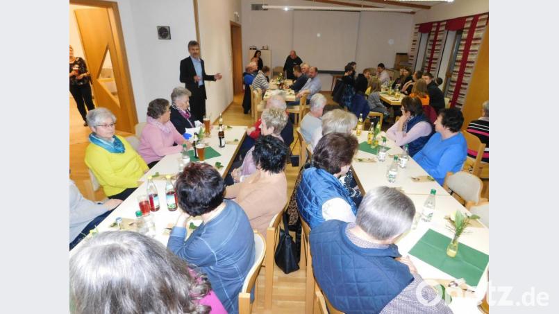 Pfarrgemeinderatsvorsitzender Thomas Horn (stehend) würdigte die Helfer für ihren Einsatz im vergangenen Jahr. Auch zeigte er Bilder von den Reisen nach Rom, Lourdes und Polen. Bild: hai