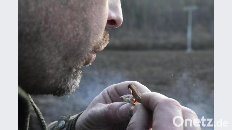 Noch etwas pusten, damit die Glut sich richtig entfalten kann. Christian Rudolf weiß, wie er in der Natur Feuer machen kann. Bild: Petra Hartl