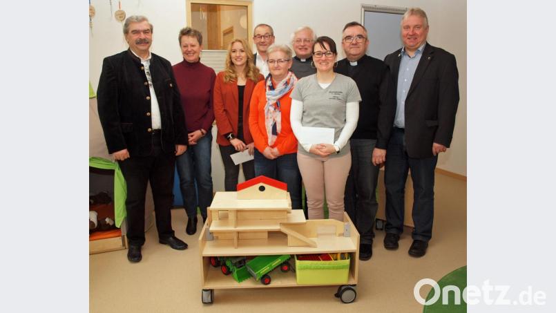 Im Namen des Siedlerbunds Ensdorf im Verband Wohneigentum übergaben Vorsitzender Reinhard Ott, Kassiererin Rita Brem-Wittman (von links) und Schriftführerin Gerlinde Hafenbradl (Vierte von links) die Gesamtspende über 800 Euro an Kindertagesstätten-Leiterin Katharina Simon (Dritte von links) aus Rieden und ihre Kollegin Manuela Mayr auf Ensdorf (Fünfte von links). Für Gemeinden und Pfarreien dankten Bürgermeister Markus Dollacker, Pfarrer Slawomir Niemczewski SDB, Pfarrer Gottfried Schubach und Bürgermeister Erwin Geitner (hinten von rechts). Bild: sön