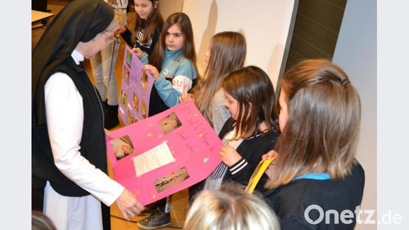 Äbtissin Laetita Fech zusammen mit den Mädchen beim Betrachten der Infoplakate zum Projekt &quot;Perlentaucher&quot;. Bild: pz