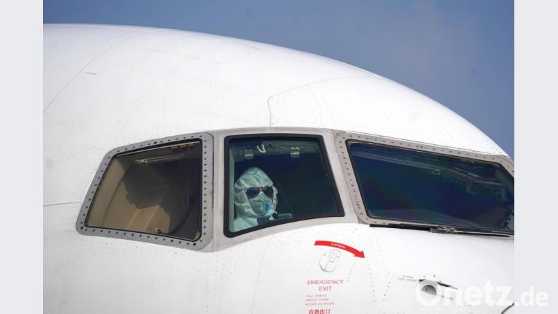 Sicher ist sicher: Ein Pilot im Schutzanzug parkt einen Jet auf dem internationalen Flughafen Wuhan-Tianhe. An Bord: 60 Tonnen medizinisches Material. Foto: Cheng Min/XinHua/dpa Bild: Cheng Min