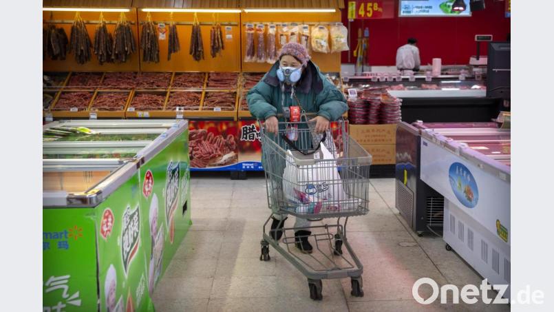 Eine Kundin trägt in einem Lebensmittelladen in Peking eine Atemschutzmaske. Foto: Mark Schiefelbein/AP/dpa Bild: Mark Schiefelbein