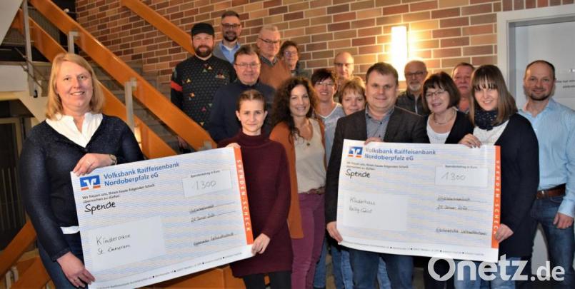 Die Weihnachtsstandl-Betreiber und Bürgermeister Karlheinz Budnik (vorne, Dritter von rechts) überreichen den beiden Vertreterinnen der Kindergärten den Erlös von insgesamt 2600 Euro. Bild: fz