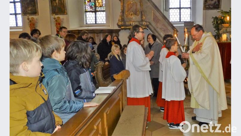 Mit gekreuzten Kerzen spendete Pfarrer Heribert Stretz (rechts) am Ende des Gottesdienstes den Blasiussegen. Bild: hl