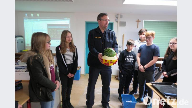 Wie Fahrradhelm Leben retten kann, demonstrierte Polizeihauptmeister Carsten Landgraf den Sechstklässlern beim Melonentest. Bild: jzk