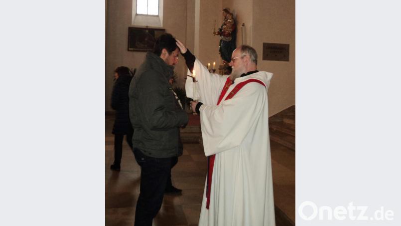 Mit zwei gekreuzten Kerzen erteilte der Priester den Segen. Bild: ksi