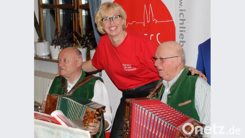 Vorsitzende Sabine Zeidler schunkelt mit Theo und Karl-Heinz von der „Weidener Standerlmusik“. Bild: fsb