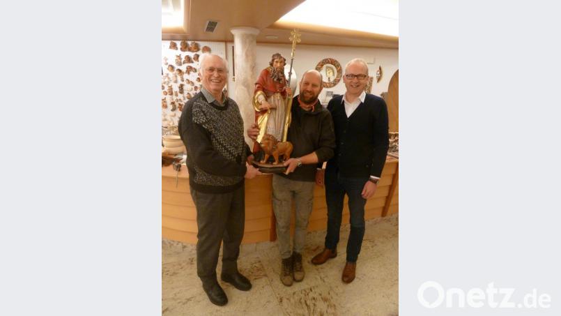 Mit sichtlicher Freude nehmen Pfarrer Hans Peter Heindl (links) und Bürgermeister Bernhard Lindner (rechts) die Statue von Schnitzkünstler Gerhard Ploner entgegen. Bild: ibj