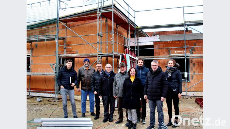 Der Baufortschritt liegt im Zeitplan, berichten Alfred Popp (Zweiter von rechts) und Jakob Neidl (links) vom Architekturbüro Popp den drei Neukirchener Bürgermeistern Winfried Franz (Vierter von links), Wolfgang Rattai (Dritter von links) und Herbert Pilhofer (Fünfter von links), der Leiterin der allgemeinen Verwaltung, Ingrid Plickert, und Manfred Stollner (Zweiter von links) vom Bauamt der Verwaltungsgemeinschaft. Über ihre Pläne für die Außenanlagen informieren David Neidl (Dritter von rechts) und Franziska Mikuta (rechts) vom Landschaftsarchitekturbüro Neidl &amp; Neidl. Bild: ds