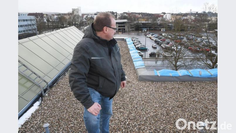 Auf 25 Meter Länge hat Sturm Sabine die Verblendung der erhöhten Dachkante aus der Verankerung gerissen. Tobias Dietl von der Hochbauabteilung der Stadt zeigt die betroffene Stelle. Bild: Gabi Schönberger