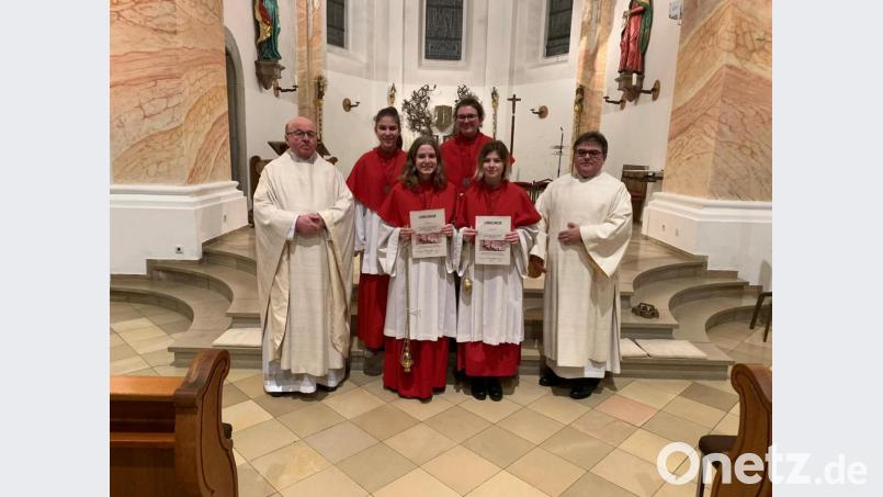 Pfarrer Wilhelm Bauer (links), Diakon Norbert Hammerl (rechts), Oberministrantin Maxima Pongratz (hinten, rechts) und Evi Demleitner (hinten, links) verabschieden die langjährigen Ministrantinnen Leonie Reng (Zweite von links) und Katja Schlosser (Zweite von rechts) . Bild: Maxima Pongratz