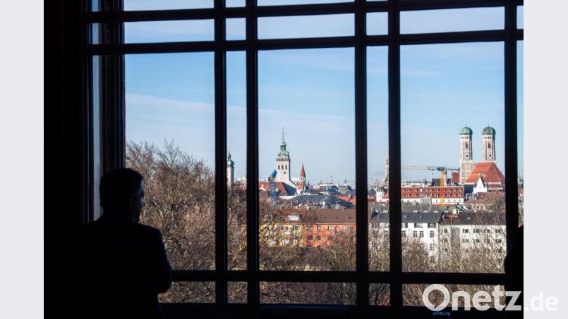 Ein Abgeordneter blickt aus einem Fenster des Landtags auf die Skyline von München mit der Frauenkirche. Bild: Lino Mirgeler