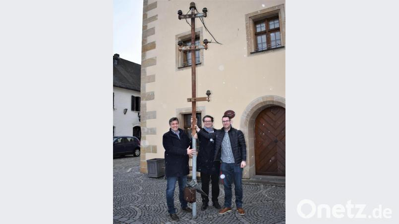 Tobias Henfling (von rechts), Markus Windisch und Bürgermeister Edgar Knobloch halten den letzten Dachständer, der vom Haus Specht (links im Bild) entfernt wurde, in den Händen. Bild: rgr