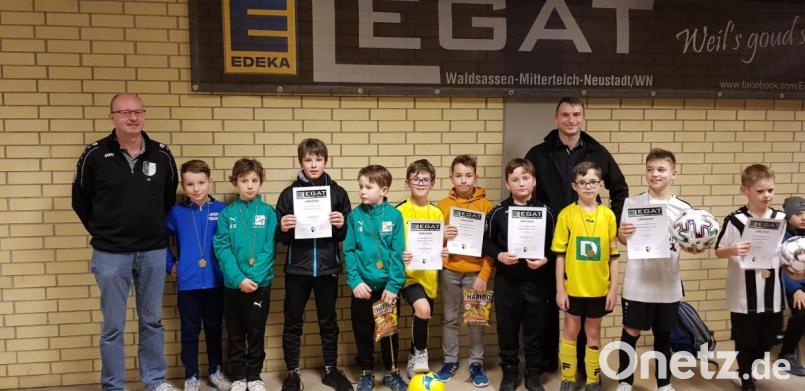 Mit Medaillen, Urkunden, Süßigkeiten und einem Ball wurden die Sieger beim Edeka-Legat-Cup der E-, F- und G-Junioren in der Sporthalle des Gymnasiums belohnt. Die Siegerehrung bei den E-Junioren nahm Stefan Legat (hinten, rechts) vor. Er unterstützt das Turnier seit vielen Jahren. Links im Bild Hauptorganisator Jo Herbrecher. Bild: prh