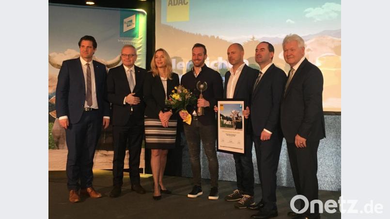 Herbert Behlert (rechts) überreicht zusammen mit Minister Hubert Aiwanger (Zweiter von rechts), Karlheinz Jungbeck, Vorstand für Tourismus des ADAC Südbayern (links),Dehoga-Landesgeschäfstführer Thomas Geppert (Zweiter von links), Bayern-Tourismus-Geschäftsführerin Barbara Radomski und Preis und Urkunde an Inmotion-Geschäftsführer Kim Kappenberger und Tom Zeller (Vierter und Fünfter von links).. Bild: ihl