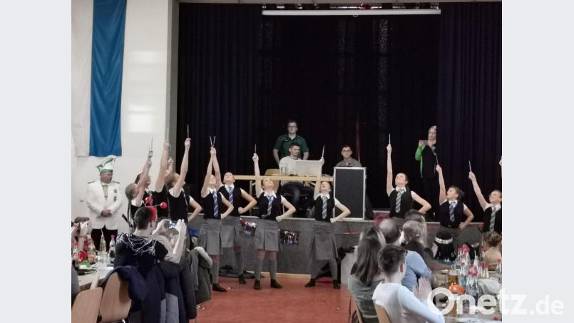 Die Juniorengarde erinnerte an die fiktive britische Zauberschule für Hexerei und Zauberei von Harry-Potter. Der Schützensprecher Ulli Bauer (hinten li) erhielt den Faschingsorden und für Musik sorgte Marco Eder. Bild: gz