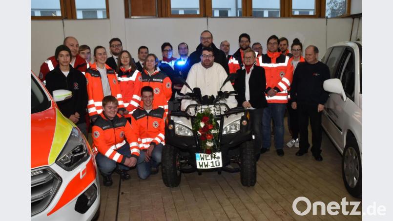 Pater Johannes Bosco und Landrat Andreas Meier, der auch stellvertretender BRK-Kreisverbands-Vorsitzender ist, nehmen auf dem Quad der Rotkreuzbereitschaft Platz. Bild: hcz