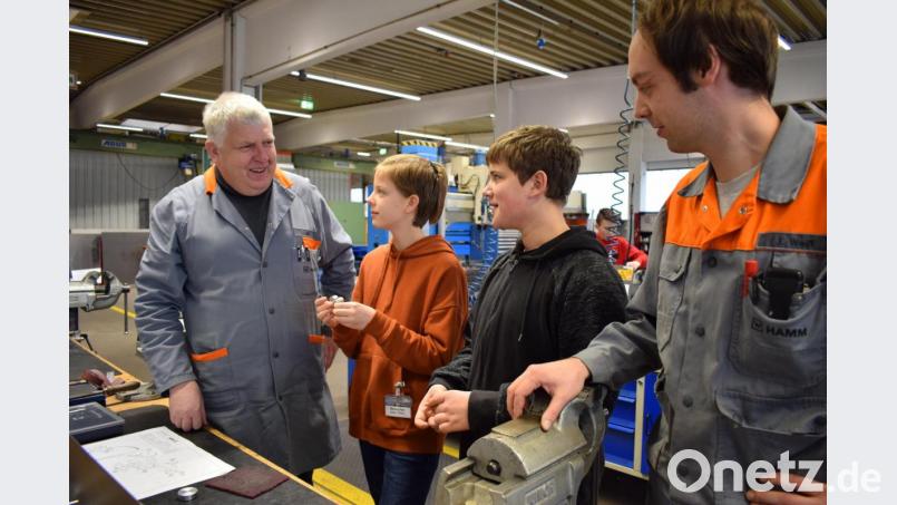 Schüler der achten Klassen der Knabenrealschule Waldsassen erhielten im Rahmen der frühzeitigen Berufsorientierung Einblick in die Ausbildungsberufe bei der Hamm AG. In der Ausbildungswerkstatt durften die Schüler mit Hilfe der Azubis ein Traktormodell fertigen. Mit im Bild Ausbildungsleiter Josef Dill (links) und Ausbilder Jacob Weiß (rechts). Bild: szl