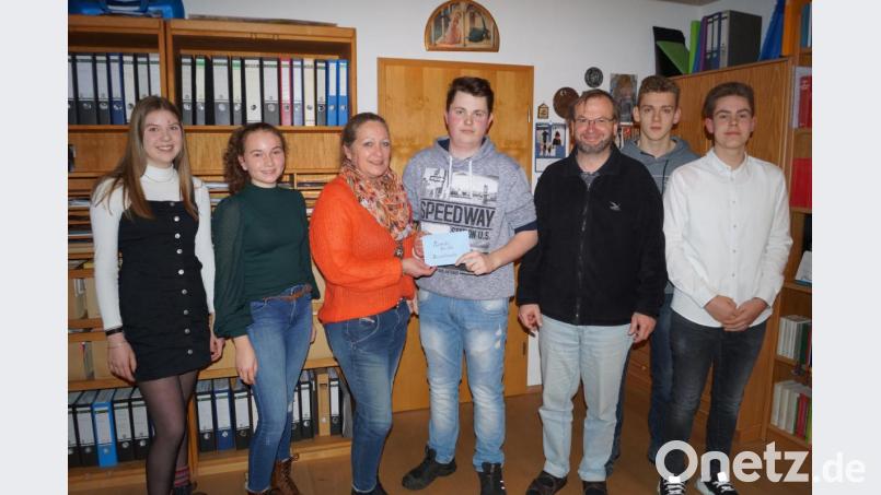 Ministranten und Pfarrer übergeben im Pfarrhof eine Spende an den Verein „Rasselbande – behinderte Kinder.“ Von links: Cina Haberberger, Lucie Lang, Heike Braun, Johannes Wolf, Pfarrer Thomas Stohldreier, Thomas Koller und Paul Wolfinger. Bild: du