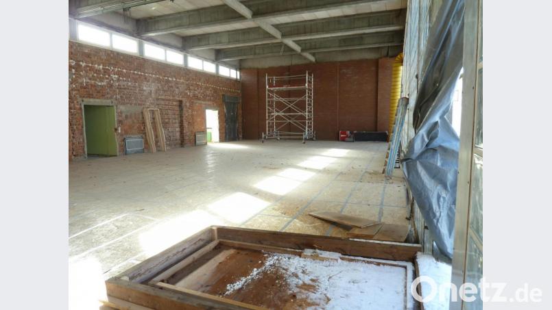 Die ehemalige Turnhalle präsentiert sich bereits als Rohbau. Der Schwingboden bleibt erhalten und ist mit USB-Platten abgedeckt, während die Holz-Deckenverkleidung abgebaut ist. Die Glasbausteinwand (rechts) wurde für eine Baustellentür geöffnet, welche Sturmtief „Sabine“ Anfang der Woche umlegte. Bild: Portner