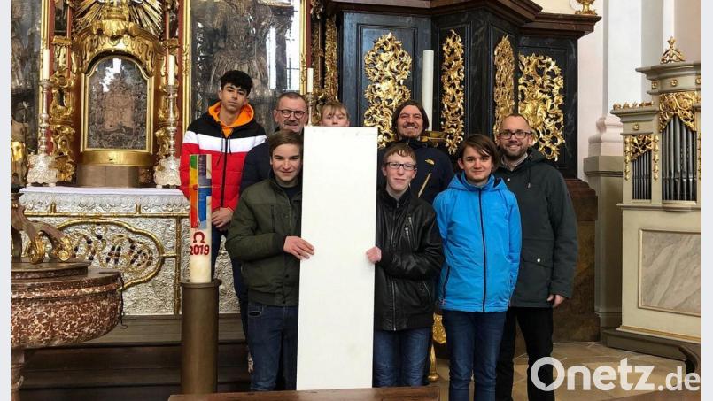 Gemeinsam mit den Schülern der 9. Mittelschul-Klasse haben Berufsschullehrer Andreas Büttner (rechts) und Mittelschullehrer Matthias Burger (3. von rechts), Stadtpfarrer Thomas Vogl (3. von links) in der Basilika besucht, um die ersten Entwürfe für eine Taufstele vorzustellen. Vorausichtlich wird sie dort ab Ostern 2020 zu sehen sein. Bild: Bild: exb – Mittelschule Wiesau