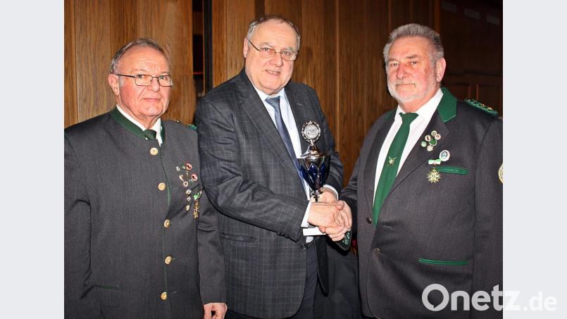 Lothar Höher (Mitte) überreicht den Wanderpokal an Karl Schmid (rechts). Auch Schützenmeister Franz Fuhrmann freut sich. Bild: R. Kreuzer