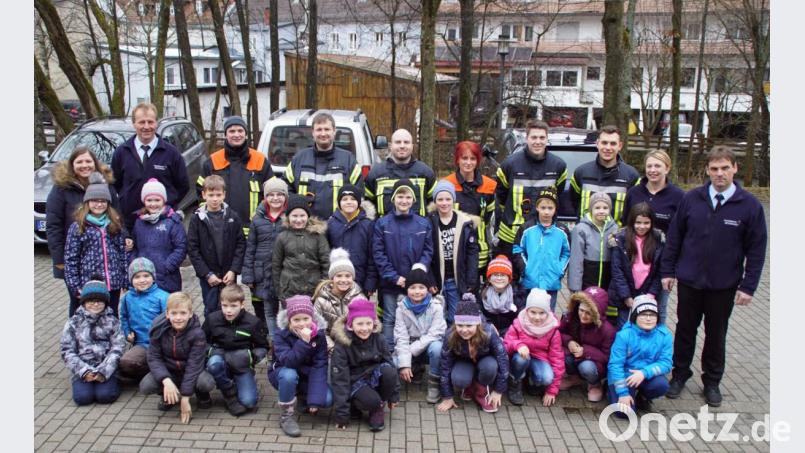 Kommandant Hubert Flöttl (rechts), sein Stellvertreter Bernhard Wild (hintere Reihe, Zweiter von links) sowie weitere Aktive informierten die Drittklässler über die Arbeit der Feuerwehr. Die Kinder waren mit Lehrerin Theresa Reiter (links) ins Gerätehaus gekommen. Bild: mmj