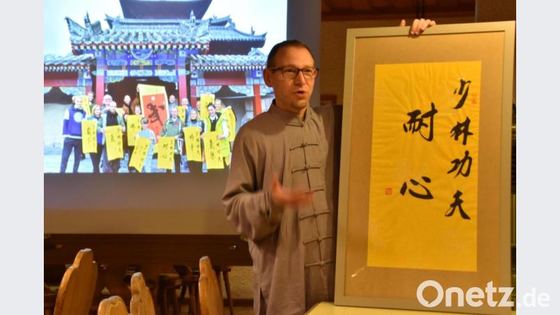 Sebastian Flaschel mit einer chinesischen Kalligraphie, wie sie jeder der Reisegruppe (im Hintergrund) von den Gastgebern im Shaolin-Tempel erhalten hat. Bild: hcz