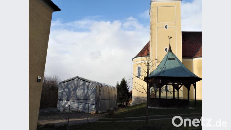 Ein Unternehmer hat bei der katholischen Kirche ein Zelt für Arbeitsgeräte errichtet. Laut Stellungnahme des Landesamtes für Denkmalschutz stört es das historische Erscheinungsbild der Kirche. Die Markträte gaben dem provisorischen Gebäude nun noch eine Schonfrist von zwei Jahren. Dann muss es entfernt werden. Bild: jml