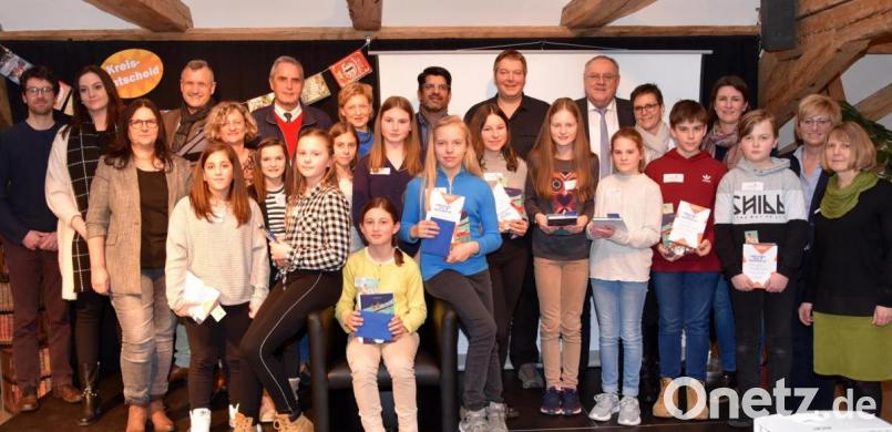 Die Mitwirkenden am Kreisentscheid des Vorlesewettbewerbs mit Jury und Ehrengästen. Siegerin ist Grace Storm (auf dem Sessel sitzend), links daneben ist Greta Schiffer, rechts Sophie Machner zu sehen. Bild: Kunz