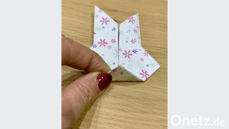 Schritt 6: An der Rückseite wird unten ein kleines Dreieck nach oben gefaltet und mit Klebstoff fixiert. Bild: mia