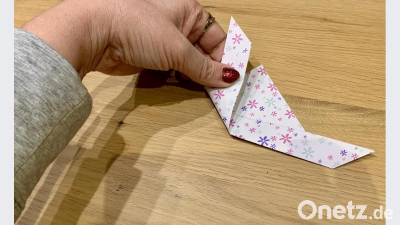 Schritt 4, erster Teil: von der Mitte aus die beiden Seiten des Papiers nach oben zur Spitze falten. Bild: mia