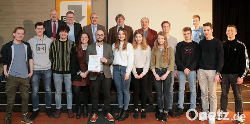 Die dreizehn Schüler des Gregor-Mendel-Gymnasiums freuen sich mit ihrem ehemaligen Lehrer Michael Karmann (vorne, Fünfter von links), der die Idee zu dem Escape Room hatte, und ihrem Lehrer Christoph Schulz (hinten, Fünfter von links), der sie in der zwölften Klasse bei der Umsetzung unterstützte, über den P-Seminar-Preis. Bild: Wolfgang Steinbacher