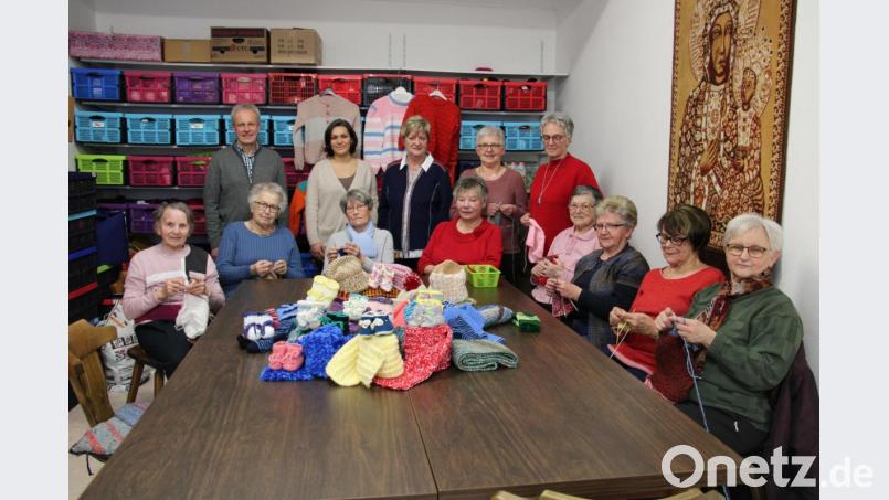 Ihr Strickeifer ist ungebrochen. 2058 Wollartikel strickten die Handarbeiterinnen der Strickrunde im letzten Jahr für einen guten Zweck. Norbert Meister und Tamara Prause (stehend von links) von Koki nahmen für ihr Netzwerk 500 Paar Babyschuhe in Empfang, die alle Leiterin Elfriede Simmerl (sitzend Vierte von links) gestrickt hat. Bild: prh