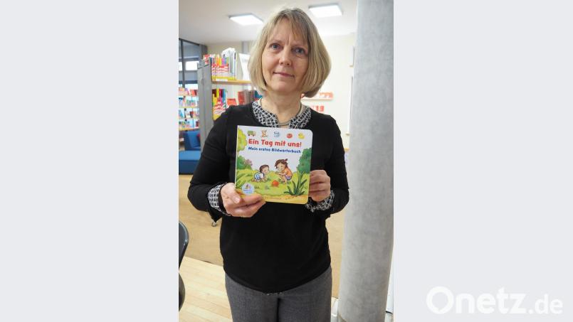 Die stellvertretende Leiterin der Regionalbibliothek Ruth Neumann zeigt den wichtigsten Inhalt des Lesestart-Sets 2012, das Buch "Ein Tag mit uns" Bild: Bühner
