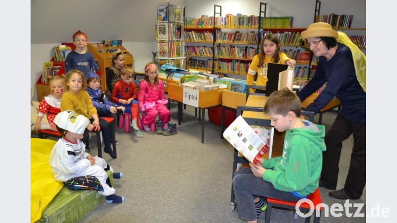 Aufmerksam lauschen die Kinder der Geschichte von den Bremer Stadtmusikanten, die sie auf dem Kamishibai-Theater mit verfolgen . Bild: gi