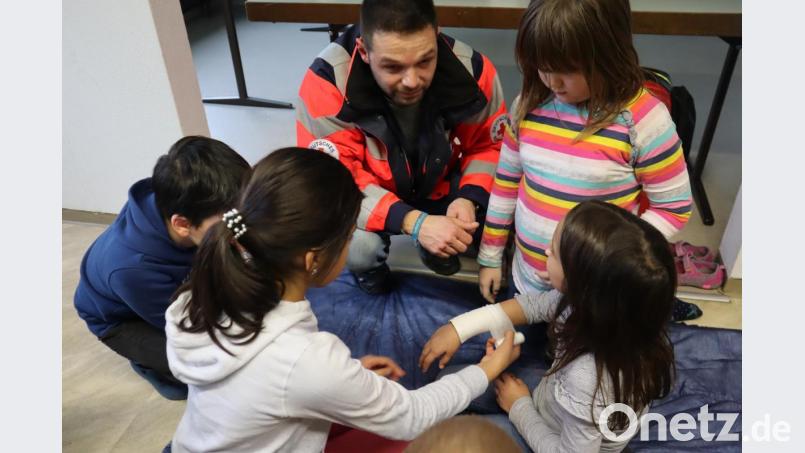 Ediz Kozanli von der Helfern vor Ort in Windischeschenbach zeigt den Kindern in der Mittagsbetreuung der offenen Ganztagsschule Windischeschenbach unter anderem wie ein Verband angelegt wird. Bild: wrm