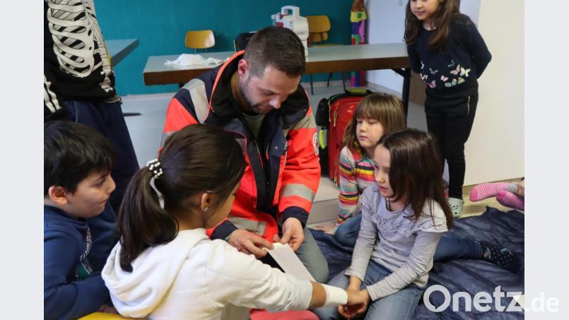 Ediz Kozanli zeigt den Kinder der Mittagsbetreuung der offenen Ganztagsschule Windischeschenbach, wie man einen Verband anlegt. Dann durften sie selber ran und es ausprobieren. Bild: wrm