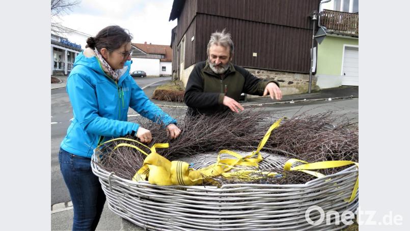 Susanne Pätz und Dieter Brandl richten das Birkenreisig im Storchennest zurecht. Danach wurde das Nest aufs Kirchendach gehoben. Bild: ubb