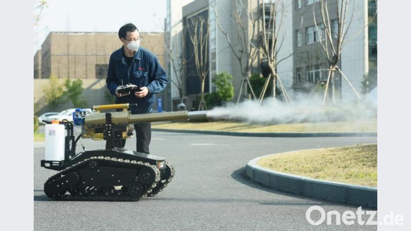 Die Corona-Panik treibt immer neue Blüten: Ein Mann mit Mundschutz präsentiert einen Desinfektionsroboter. Der Roboter kann eine Fläche von 10.000 Quadratmetern pro Stunde desinfizieren und soll das medizinische Personal vor der Ansteckung mit dem Coronavirus schützen. Bild: Long Wei/SIPA Asia via ZUMA Wire/dpa