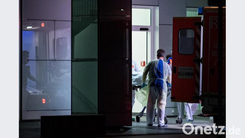 Mitarbeiter aus dem Leber- und Infektionszentrum des Universitätsklinikums in Düsseldorf nehmen den ersten mit dem Coronavirus Infizierten in NRW in Empfang. Foto: Guido Kirchner/dpa Bild: Guido Kirchner