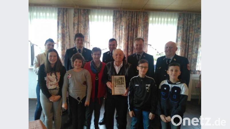 Jubilar Alois Simbeck (mit Urkunde) samt Ehefrau Franziska und den Enkelkindern, freute sich über den Besuch einer Abordnung der Thansteiner Wehr. Bild: rk