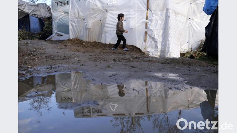Ein Junge geht nach einem Regenfall an einem provisorisch errichteten Zelt außerhalb des Flüchtlingslagers Moria (Griechenland) vorbei. Die Lager auf den Inseln Lesbos, Samos, Chios, Kos und Leros sind völlig überfüllt, und die Atmosphäre ist entsprechend verzweifelt. Bild: Aggelos Barai/AP/dpa