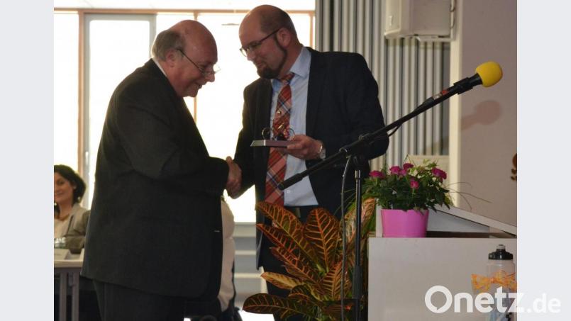 Georg Hecht (links) bekommt vom Personalratsvorsitzenden Oberstudienrat Tobias Lang ein solarbetriebenes Modell eines Fahrradfahrers geschenkt. Bild: sfo