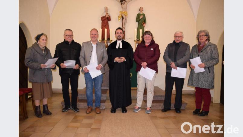 Pfarrer Stefan Fischer (Mitte) dankt den sechs Paten, die die Restaurierung der Altarleuchter ermöglichen. Bild: wku