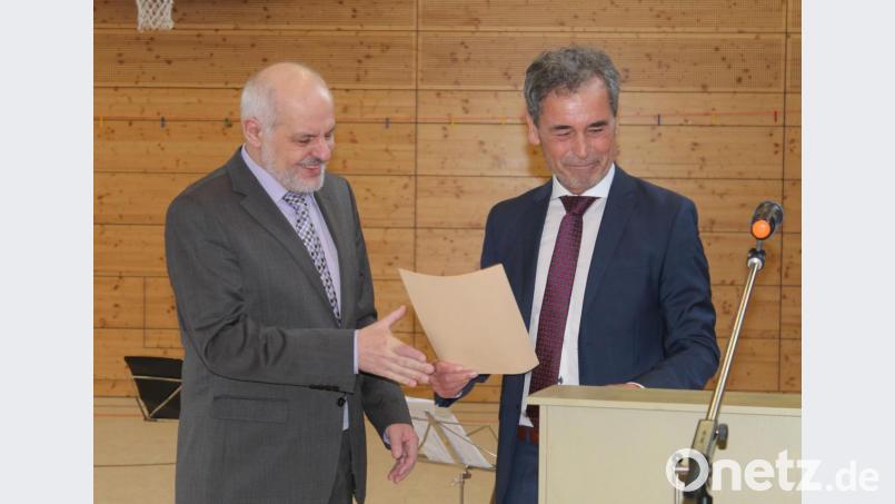 Schulamtsdirektor Rudolf Kunz (rechts) überreicht dem scheidenden Schulleiter Ulrich Sangl eine Urkunde. Bild: sfo