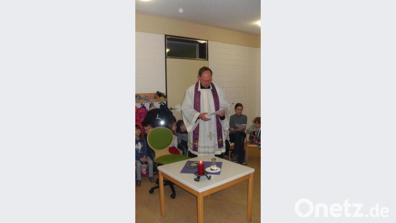Pfarrer Heribert Stretz feierte im Kinderhaus Pusteblume Kastl eine Aschermittwochs-Andacht und legte den Kindern und dem Kinderhauspersonal das Aschekreuz auf. Bild: rpp
