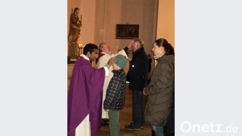 Die Priester zeichnen das Kreuz auf die Stirn der Gläubigen. Bild: ksi