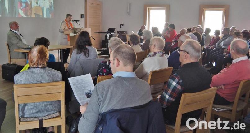 Reinhard Erös (sitzend am Tisch) wird von Martina Merk, Kolpingverbandsvorsitzende Tirschenreuth, begrüßt. Bild: Bühner